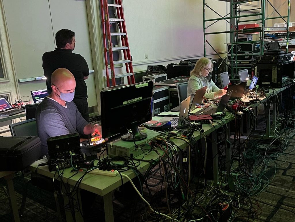 Table full of computers, cables and video editors